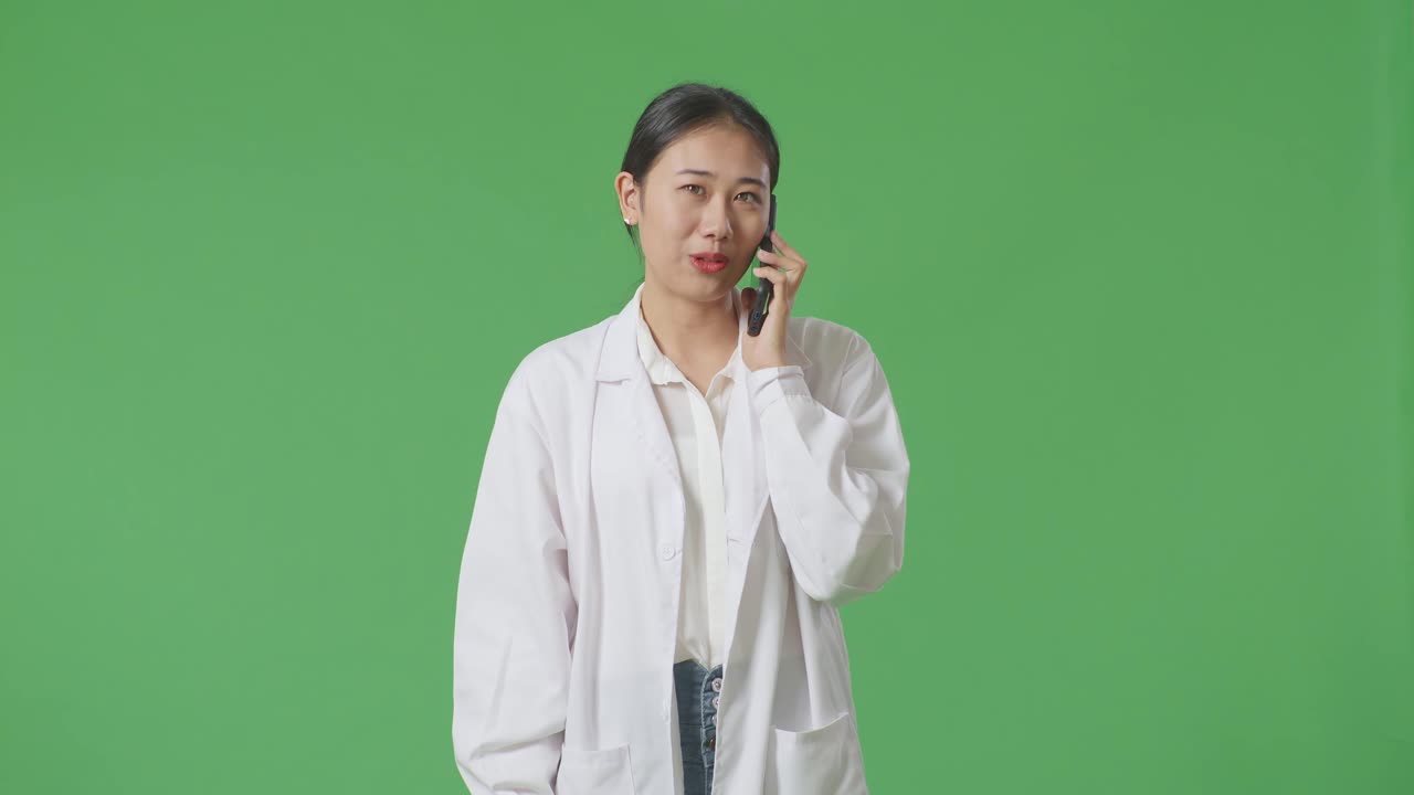 실험실 코트 를 입은 여자 가 전화 로 이야기 하고 있다