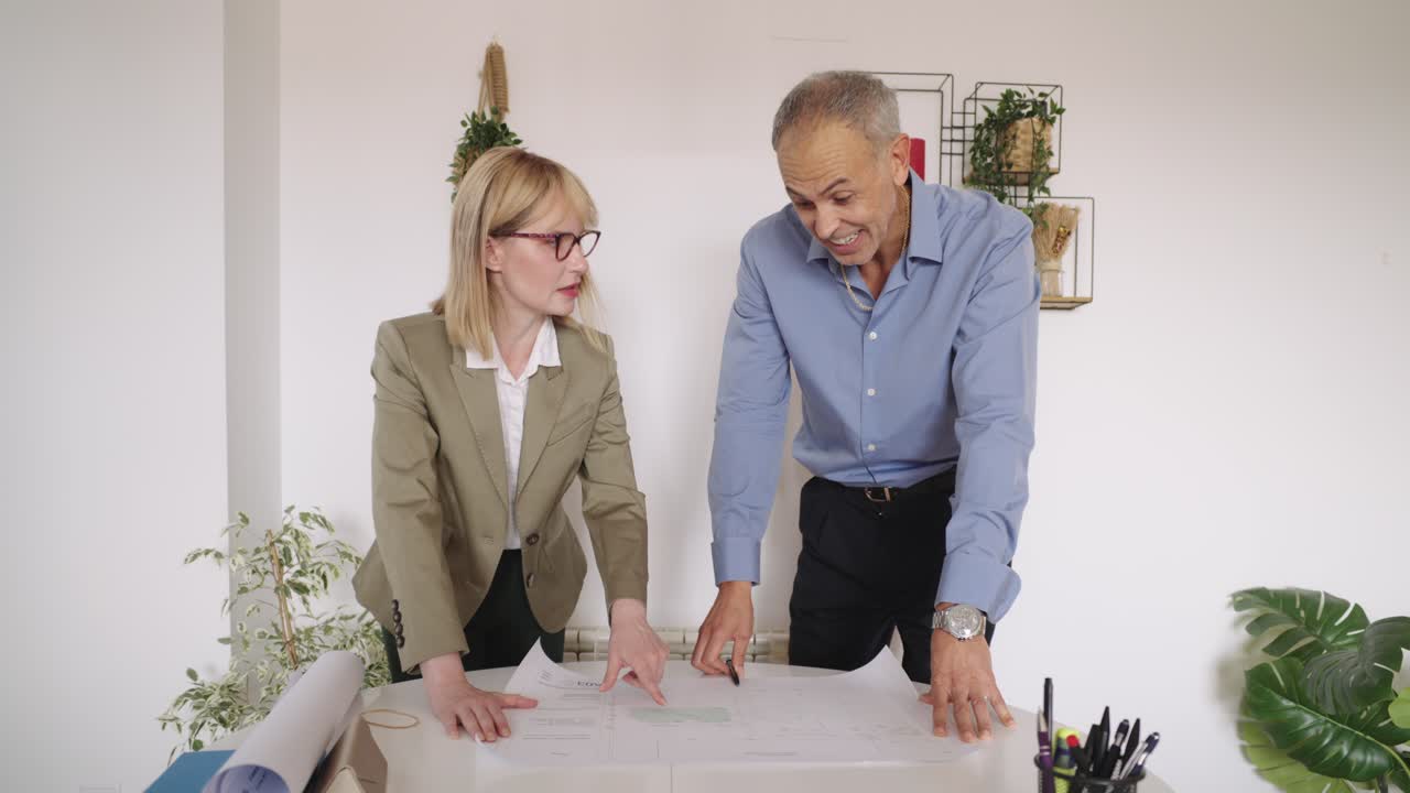 Team Discussing Blueprint in Office