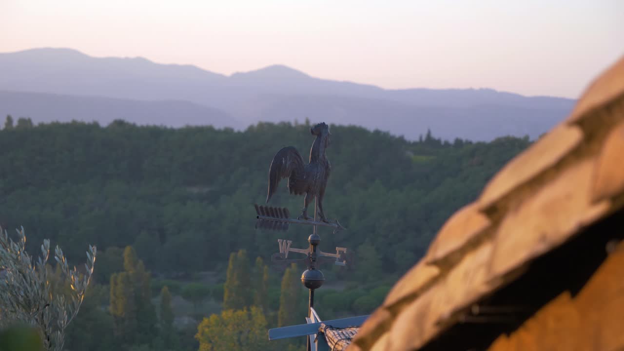una paleta meteorológica que gira en el viento bajo una puesta de sol en el campo