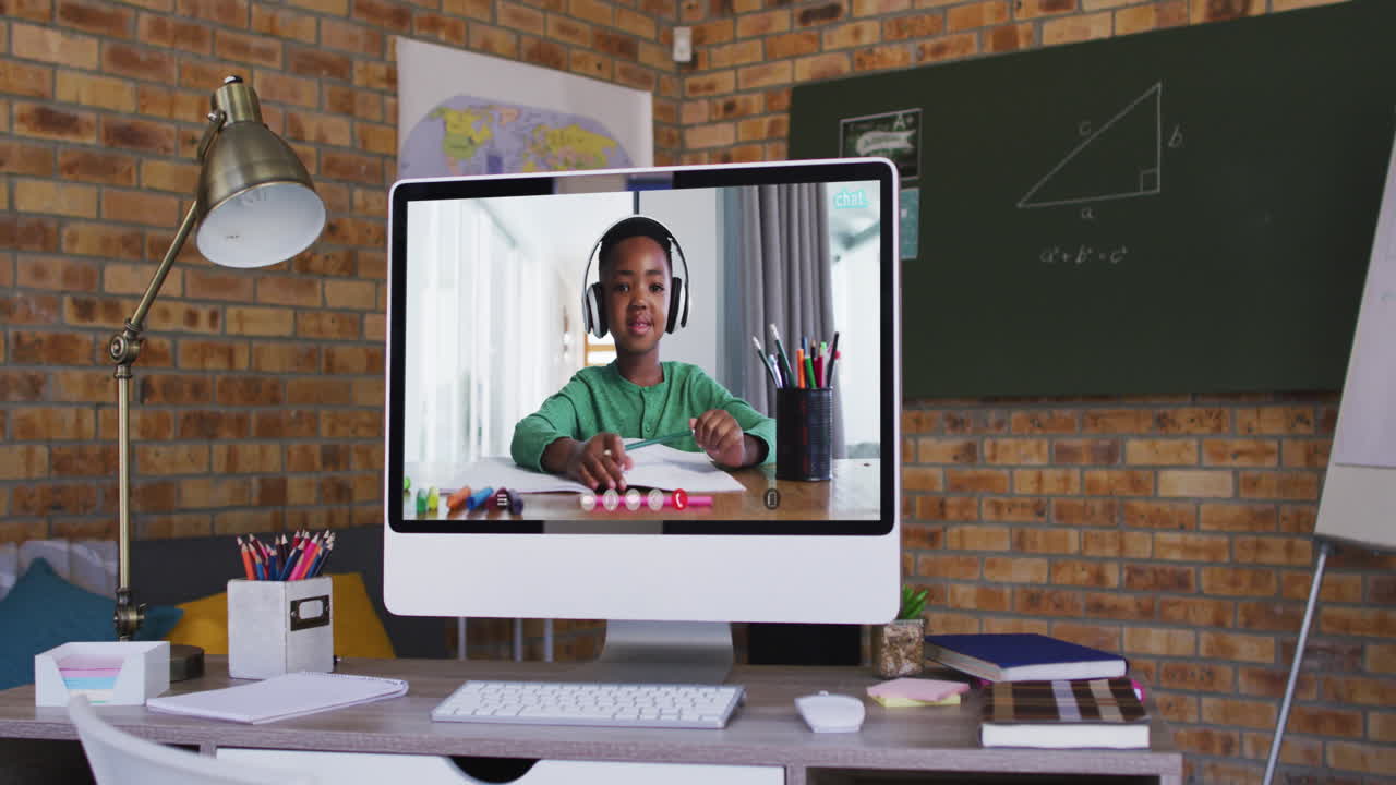 African american boy having online school lesson on screen of computer on desk