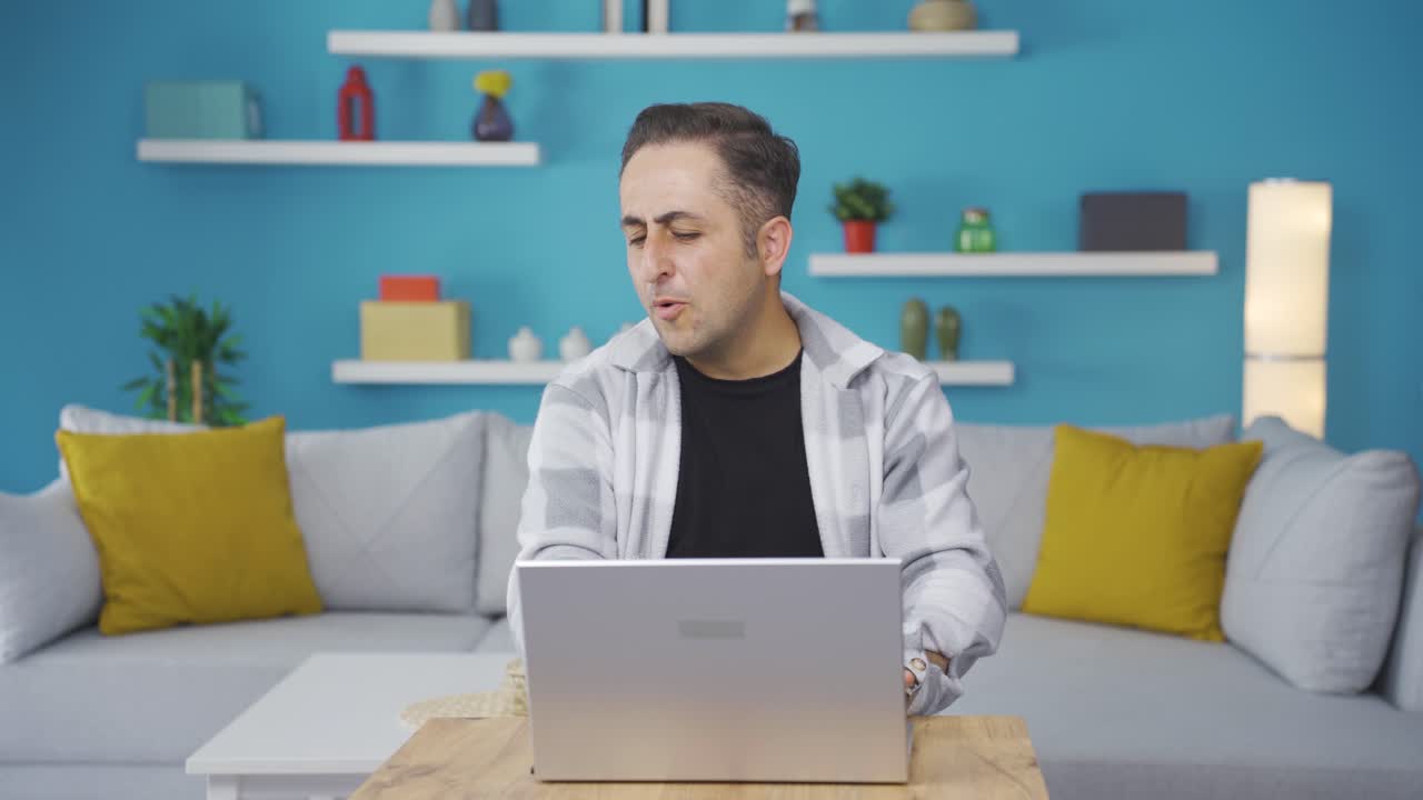 노트북을 보는 남자는 행복하고 춤을 추고 있습니다.