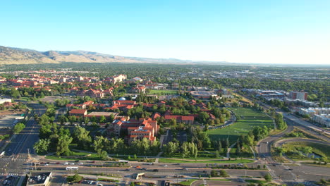 Amanecer-Aéreo-Sobre-El-Campus-De-Boulder-De-La-Universidad-De-Colorado-Con-Tráfico-Y-Automóviles-En-Primer-Plano