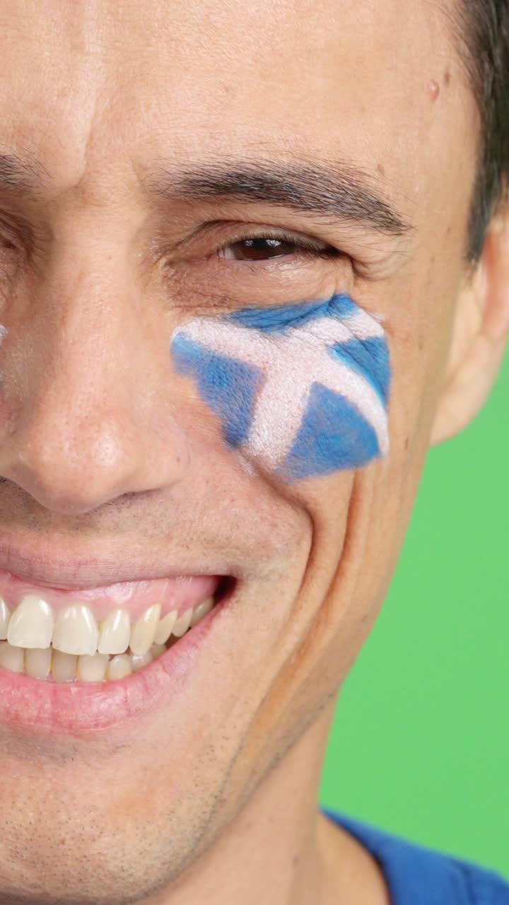 Man with a scottish flag painted on the face smiling
