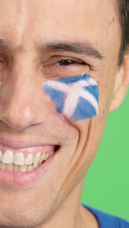 man with a scottish flag painted on the face smiling