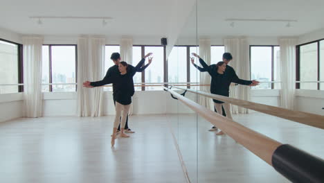 young ballet duet practicing synchronic moves in dance studio