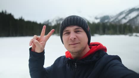 man taking selfies in snowy mountains
