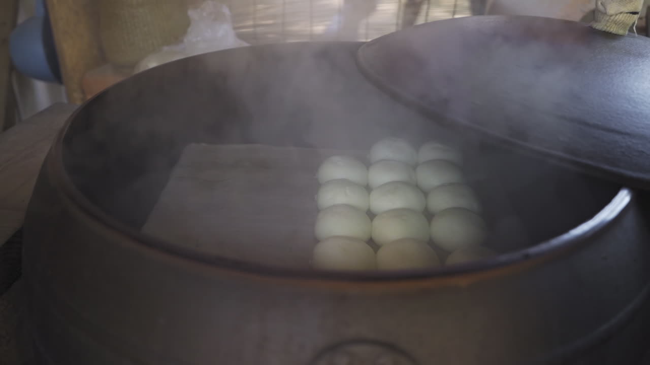 Bakpao kacang merah buatan sendiri, dijual di Pulau Nami, Korea Selatan, dikukus dalam tungku besi tua, dengan pergerakan kamera sedang ke kanan dalam gerakan lambat.