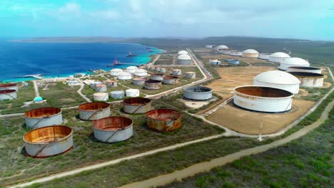 4k-Aerial-tilt-down-reveal-of-oil-storage-tanks-and-silos,-Bullenbaai-Oil-Terminal-in-Curacao