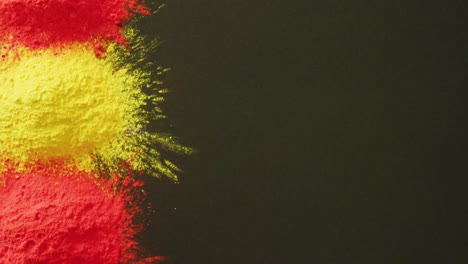 Video-of-red-and-yellow-coloured-powders-with-copy-space-on-black-background