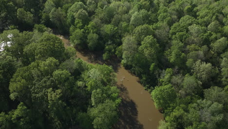 Wolf-river-winding-through-lush-forests-in-collierville,-tennessee,-sunlight-dappling-through-trees,-aerial-view