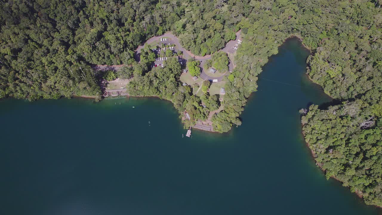 lago eacham con agua turquesa y vegetación exuberante en atherton tableland, queensland, australia - toma aérea de drones