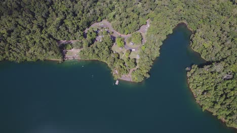 lago eacham con agua turquesa y vegetación exuberante en atherton tableland, queensland, australia - toma aérea de drones