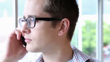 Casual-businessman-smiling-and-speaking-on-phone