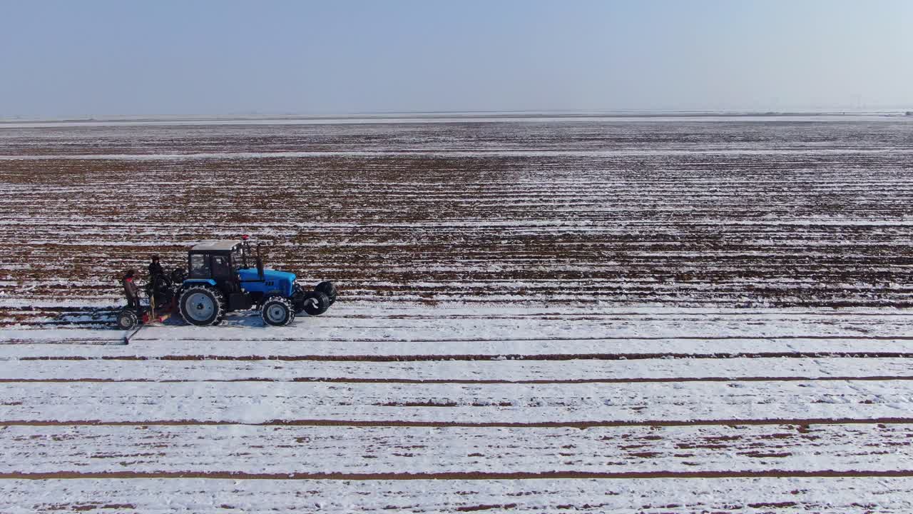 tractor agrícola arando el campo nevado durante el invierno en ucrania
