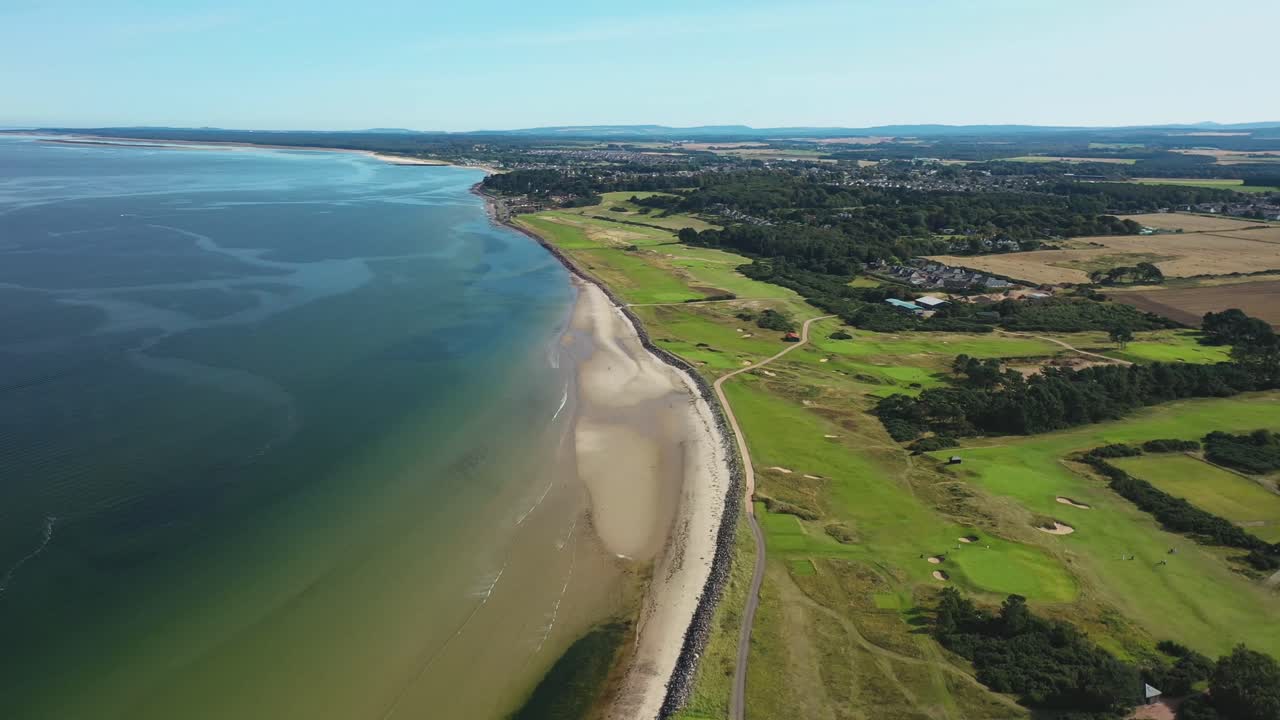 Luftfoto af kystlandskab med golfbane og strand