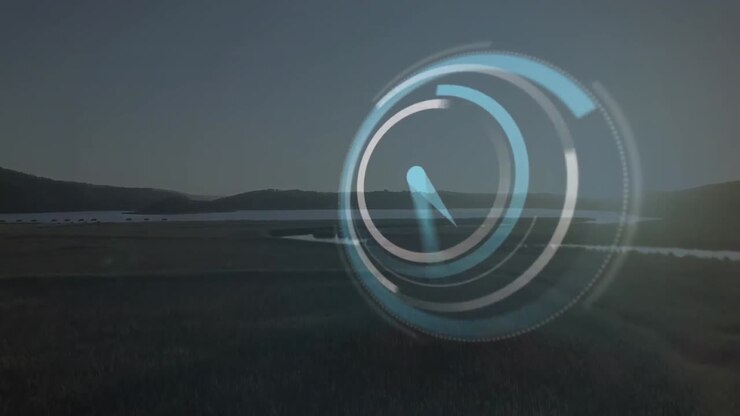 Animation of digital clock over aerial view of green landscape with lake and mountains against sky