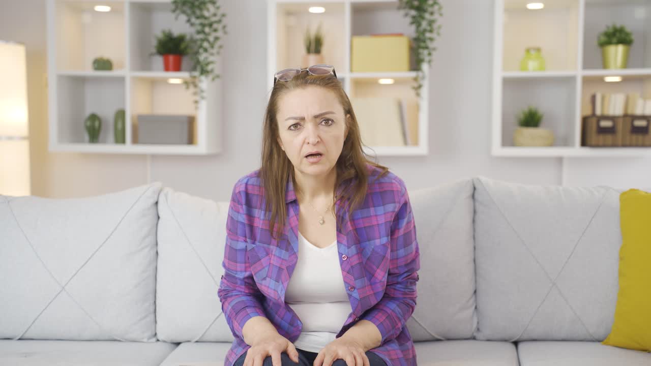 여자는 혼란스럽게 카메라를 쳐다보고 있습니다.