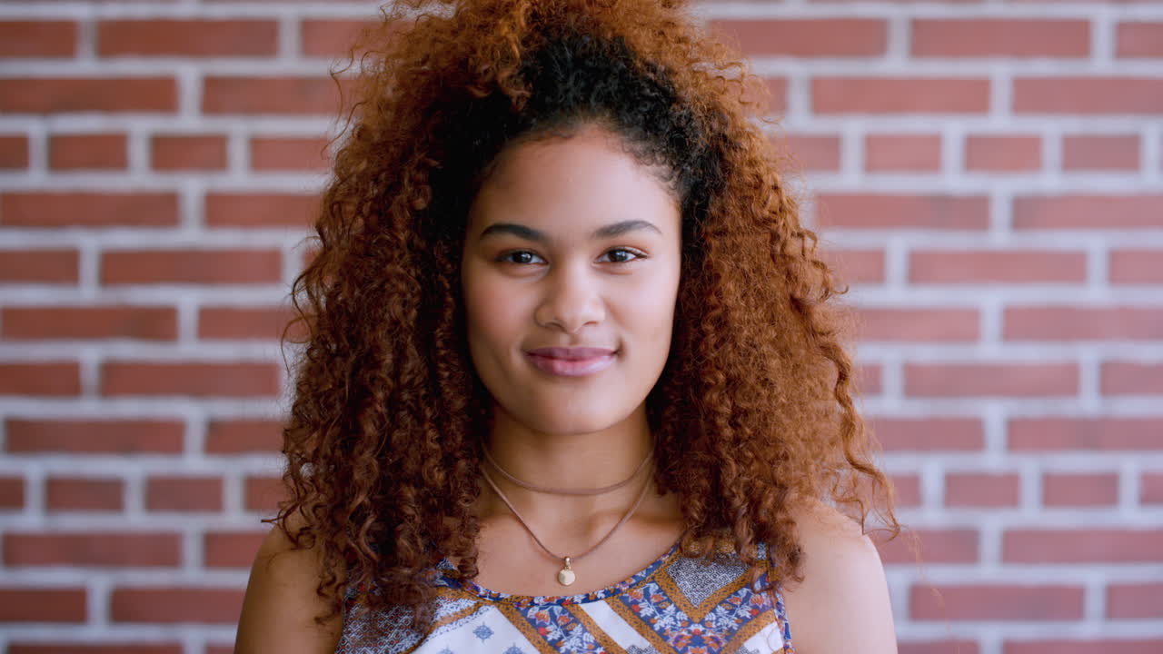 mujer negra, cara y pared de ladrillo con sonrisa