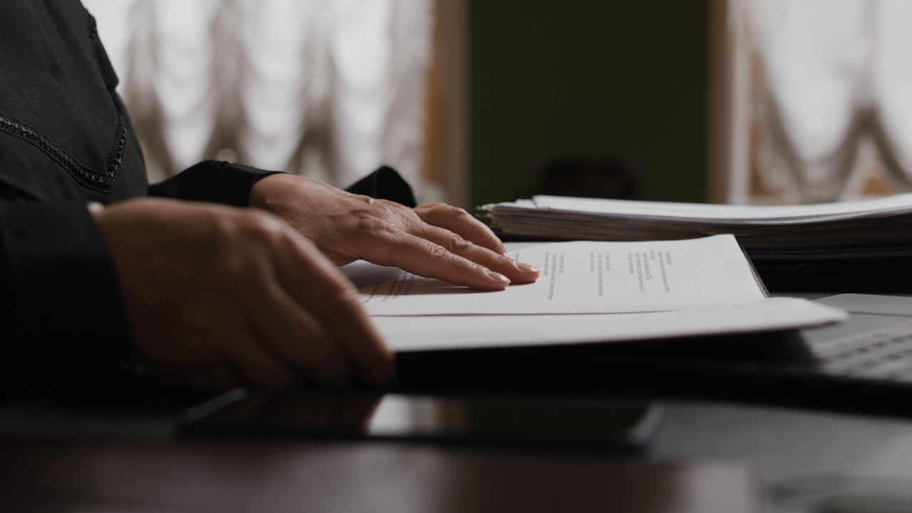 Person Reading Documents at a Desk