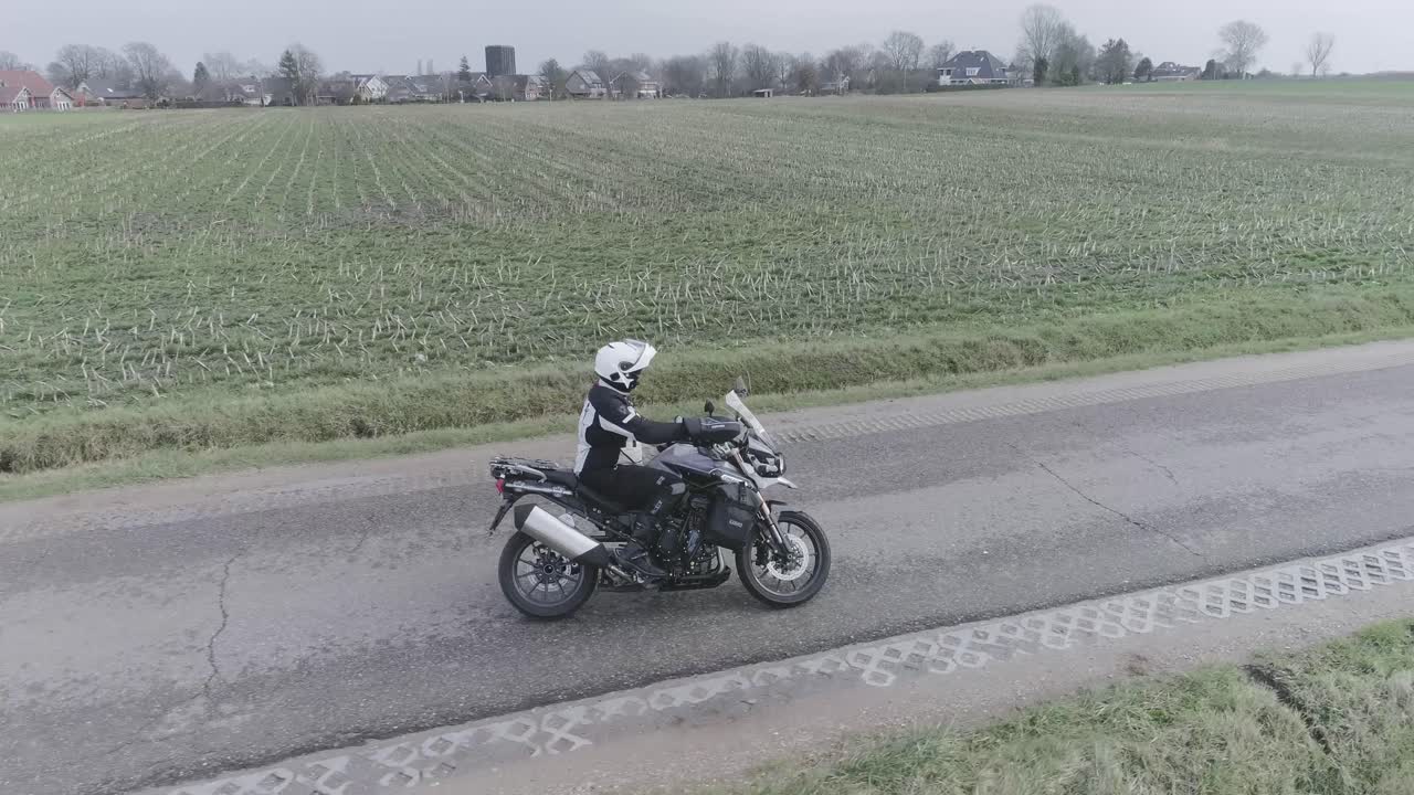 Drone shot of motorcyclist driving and doing slalom