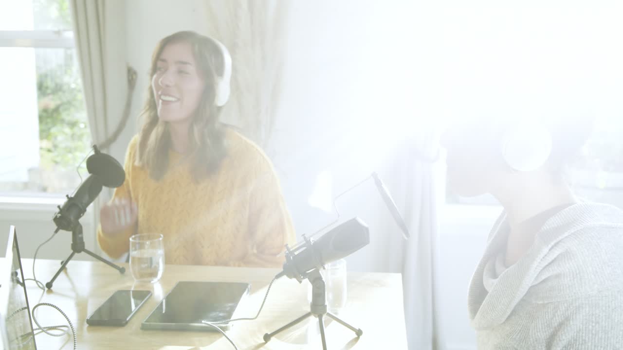 Diverse conduttrici di podcast che cliccano sul touchpad per avviare l'audio e cantano nei microfoni in uno studio casalingo.