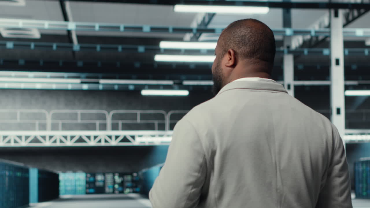 Technician walking in data center workplace with rows of mainframes