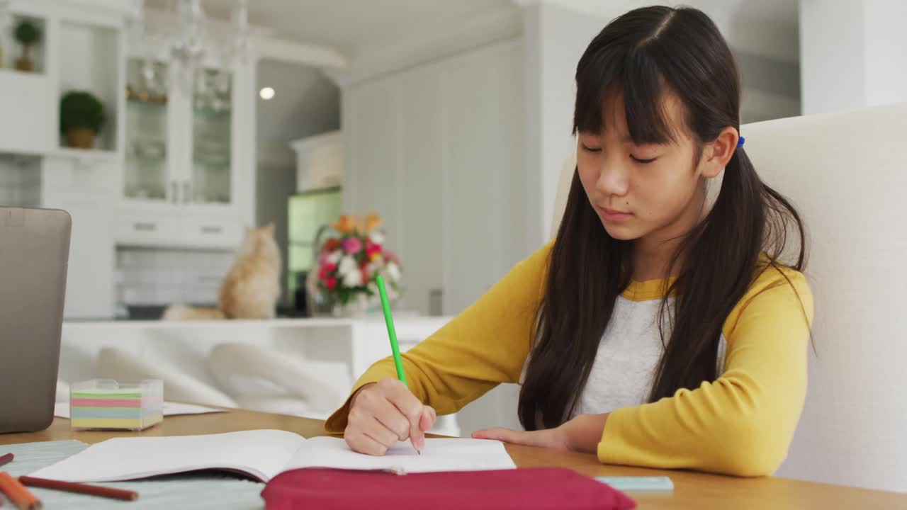아시안 아버지 는 스마트폰 과 노트북 을 사용 하여 아들 과 딸 과 함께 주방 에서 일 하고 학교 과제 를 하고 있다
