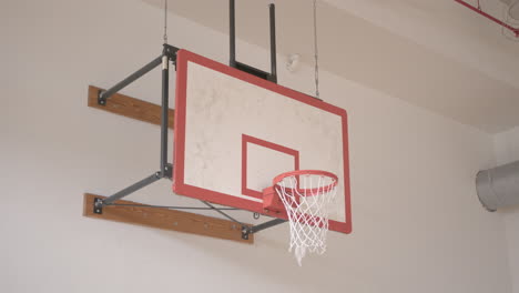 wide pan right of a basketball going into a hoop in slow motion