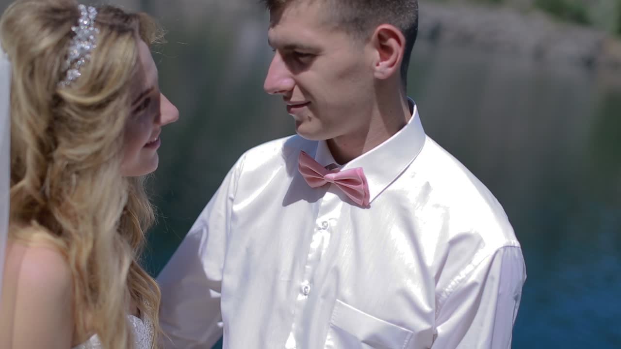 Wedding Couple Walking Near Water. Loving wedding couple walking and kissing near water