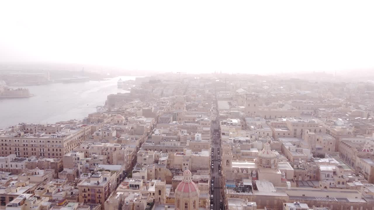 Giornata molto caliginosa su La Valletta, Malta, mentre un drone vola all'indietro verso il castello.