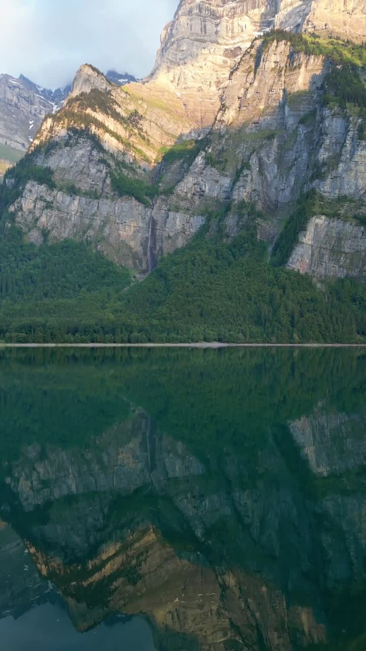 Glarus Alpernes spejling i Klöntal-søens Klöntalersee rolige vandoverflade, Schweiz, vertikal video.