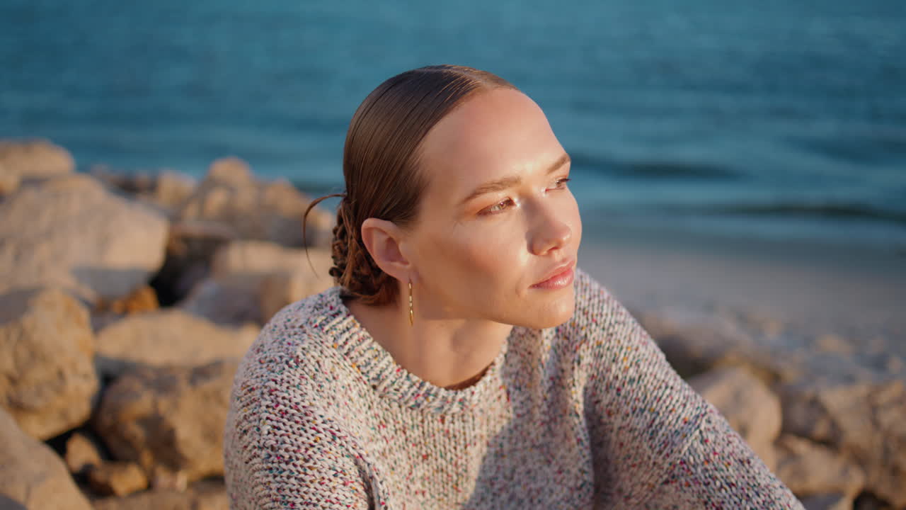 빛을 가까이서 포즈를 취하는 매력적인 여인. 해가 지는 것을 즐기는 편안한 여행자