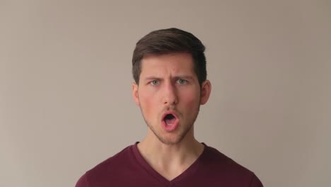 Young man being surprised and acting in negation with strong emotions, medium close-up facing camera still shot