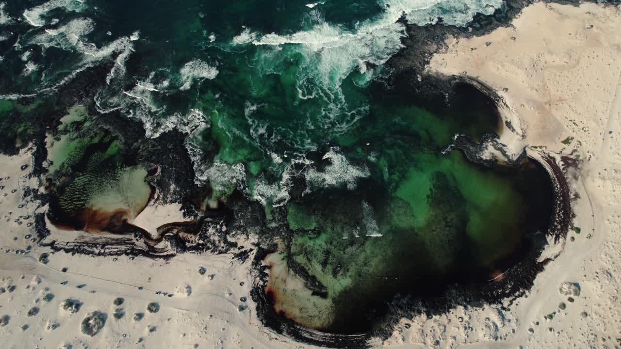 Aerial drone ocean tide revealing lava rock tidal pools