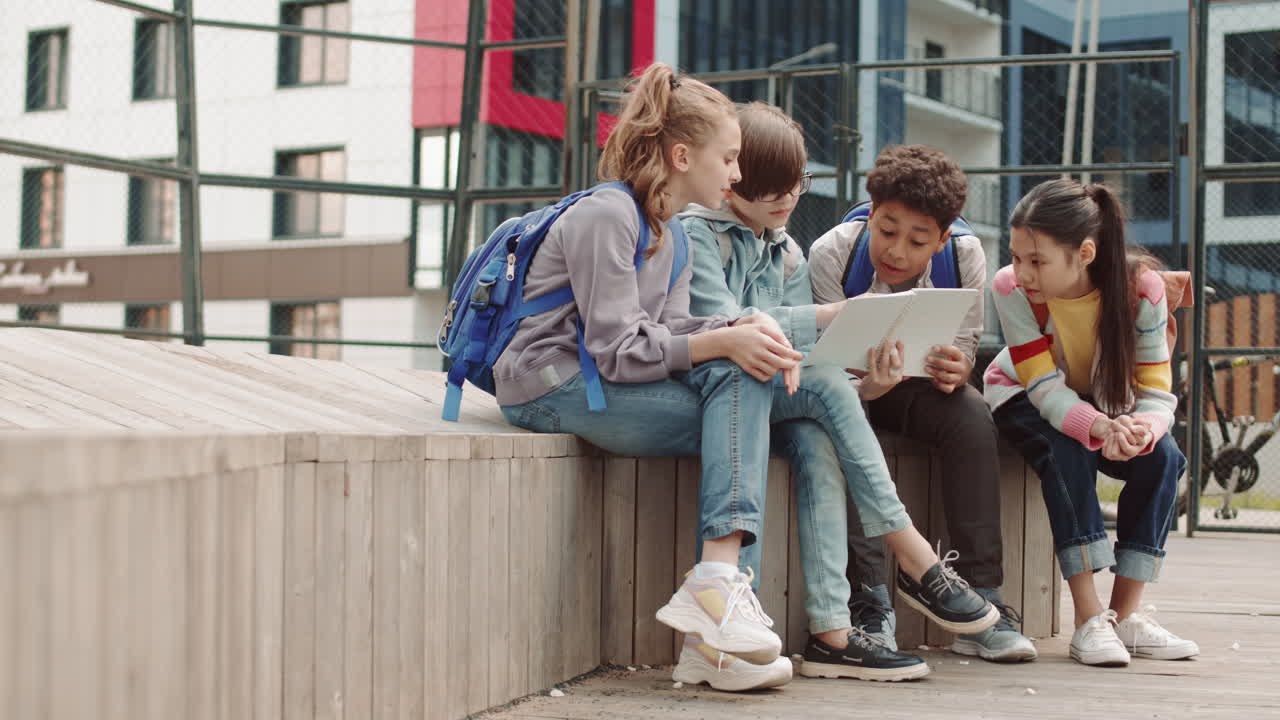 School Kids Looking at Copybook Outdoors
