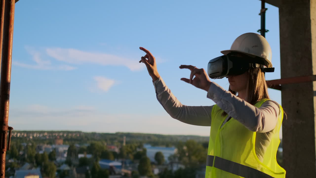 una mujer ingeniera en un sitio de construcción en gafas de realidad virtual mueve sus manos simulando el trabajo de la interfaz del futuro control innovador de la construcción de edificios