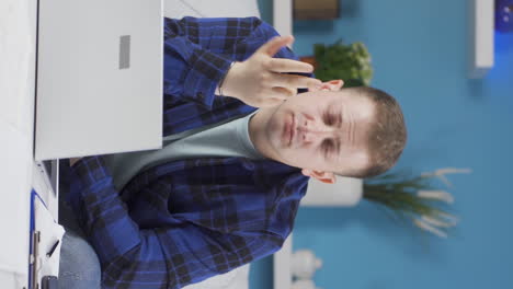 Vertical-video-of-Home-office-worker-man-thinking-looking-at-camera.