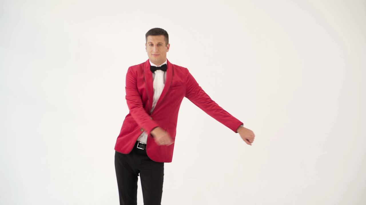funny man in red suit is making funny movement with his hands and body on a white background in the studio. Fool around