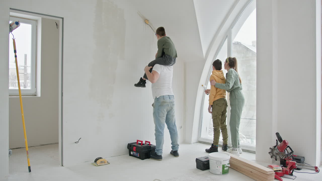 Famiglia che dipinge un muro in una nuova casa
