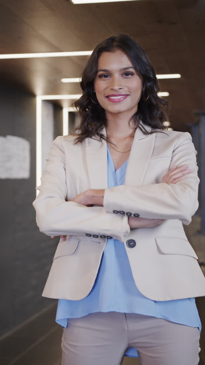 Vertical video of portrait of happy middle eastern businesswoman in casual office, slow motion
