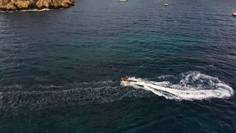 tourists jet skiing in the ocean near ibiza island in spain at summer