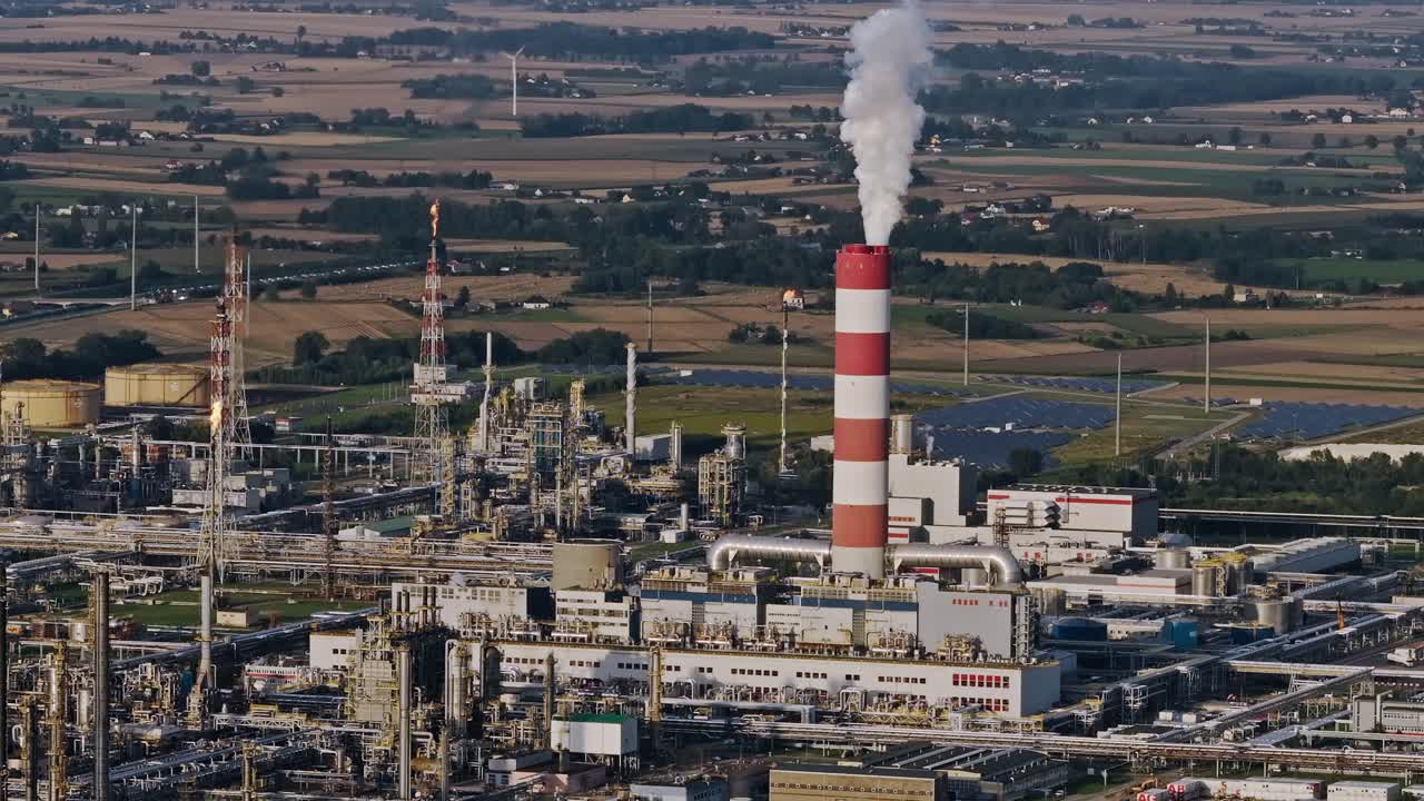 Industrial chimney emits smoke across calm countryside symbolizing human renewal
