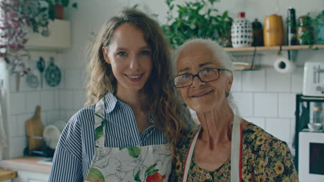 portrait of happy elderly grandmother and young granddaughter in kitchen