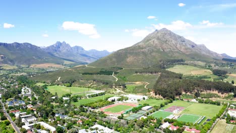 Aerial-of-Coetzenburg,-Danie-Craven-athletic-stadium,-surrounding-Hottentots-Holland-mountains,-Jonkershoek-Nature-reserve-and-surrounding-neighbourhood-of-Stellenbosch