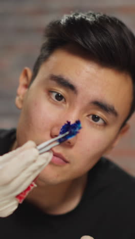 home asian teacher learns experiment result on colored litmus test with little student with yellow goggles during fun science lesson in lab closeup