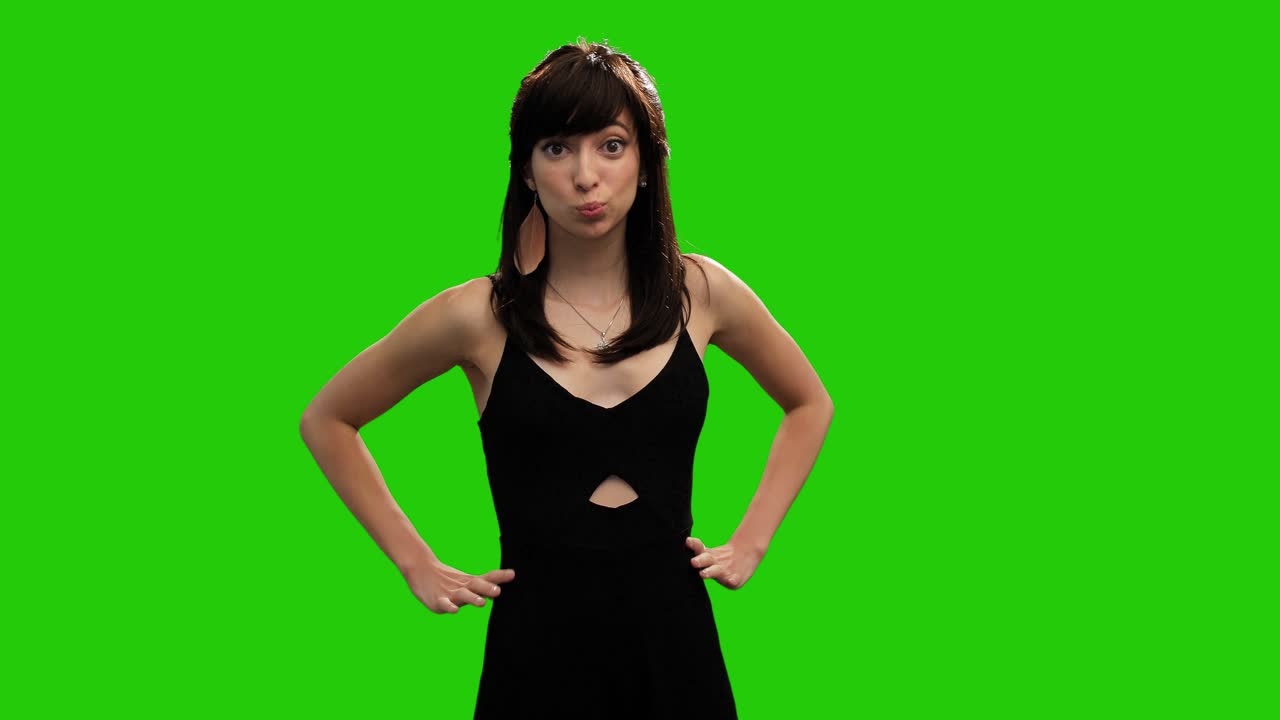 Menina caucasiana fofa de vestido preto surpresa em tela verde.