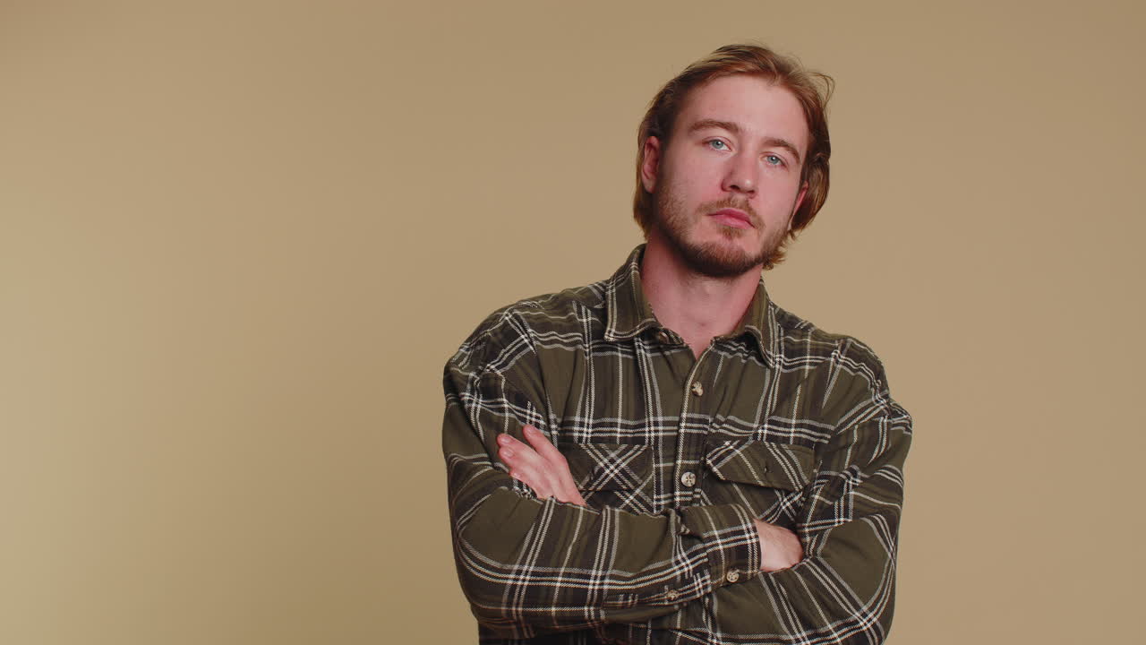 Upset man in casual shirt showing thumbs down sign gesture, disapproval, dissatisfied dislike