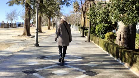 foto de seguimiento de una mujer caminando por las soleadas calles de ronda, españa