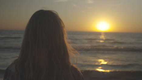 handheld shot of woman watching the sunset near the ocean.  shot in 4k