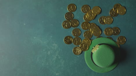 foto de estudio superior de sombrero de copa de duende verde y montones de monedas de oro para celebrar el día de san patricio